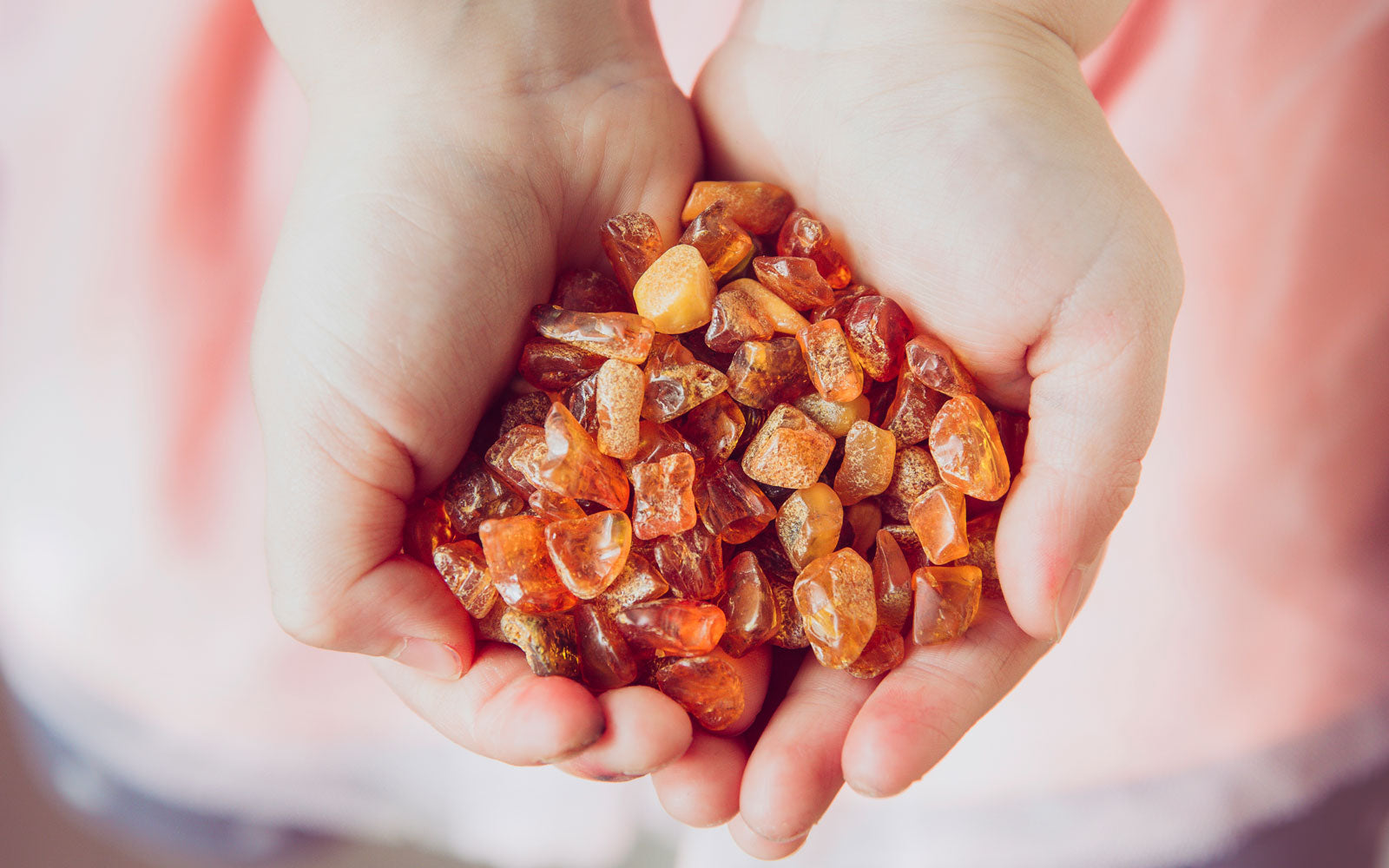 Person holding a handful of baltic amber beads