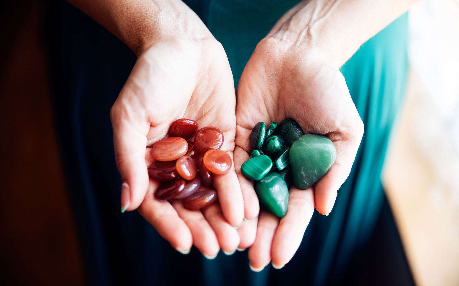 Woman holding selection of orange and green healing crystals
