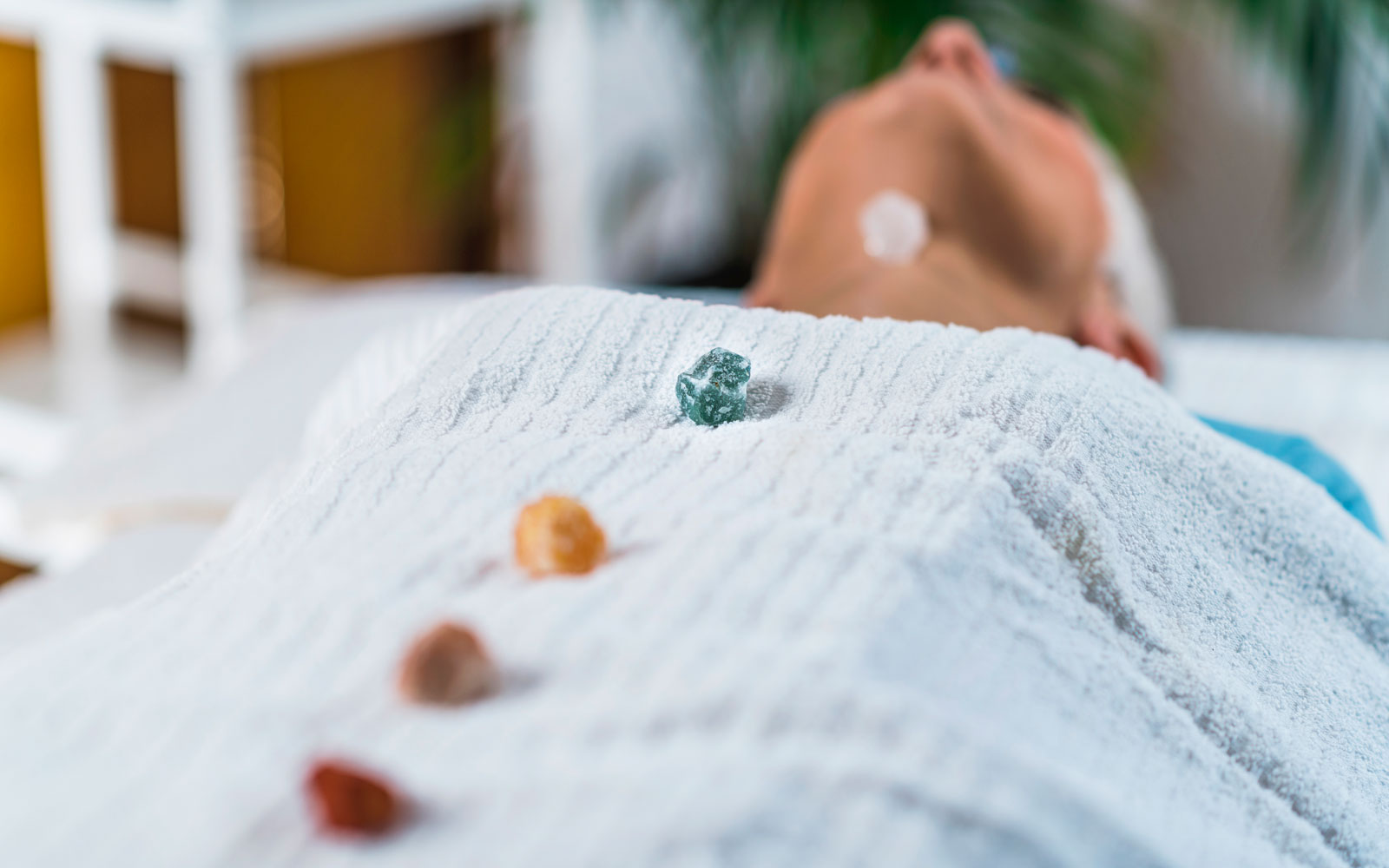 Person meditating with chakra stones