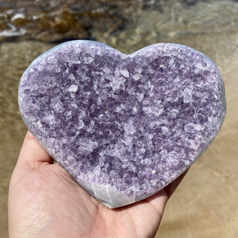 person holding amethyst quartz heart