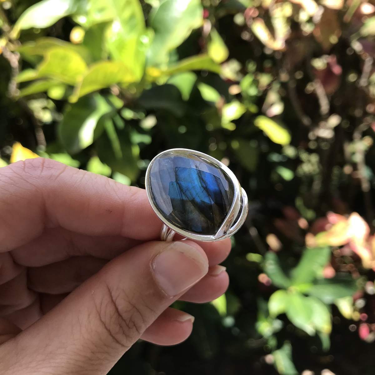 person holding faceted labradorite adjustable ring