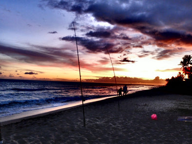 Fishing poles on the beach in Hawaii as the sun sets
