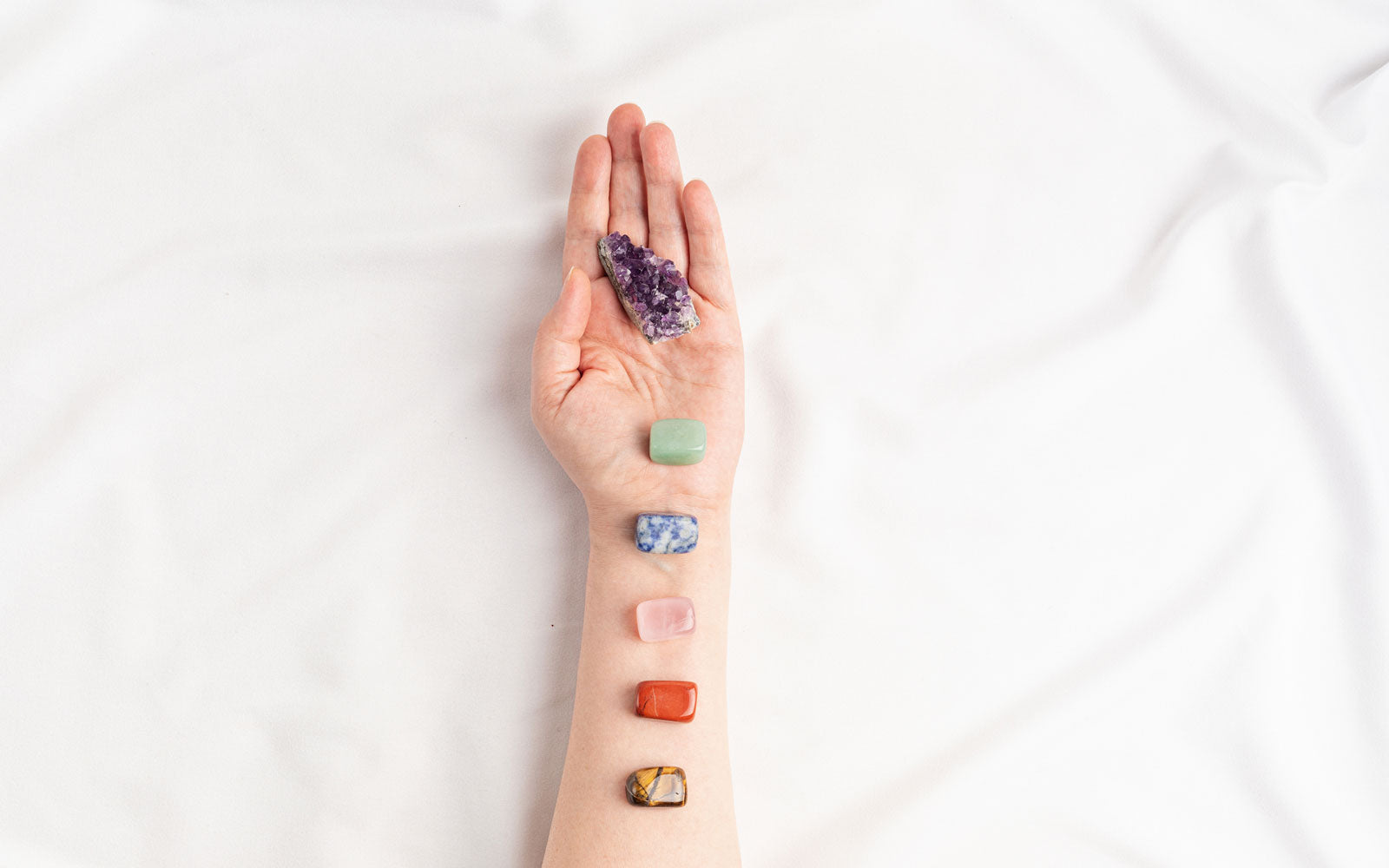 Healing Stones lined up along a person's arm and palm