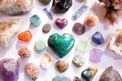 Heart stone surrounded by stones and healing crystals