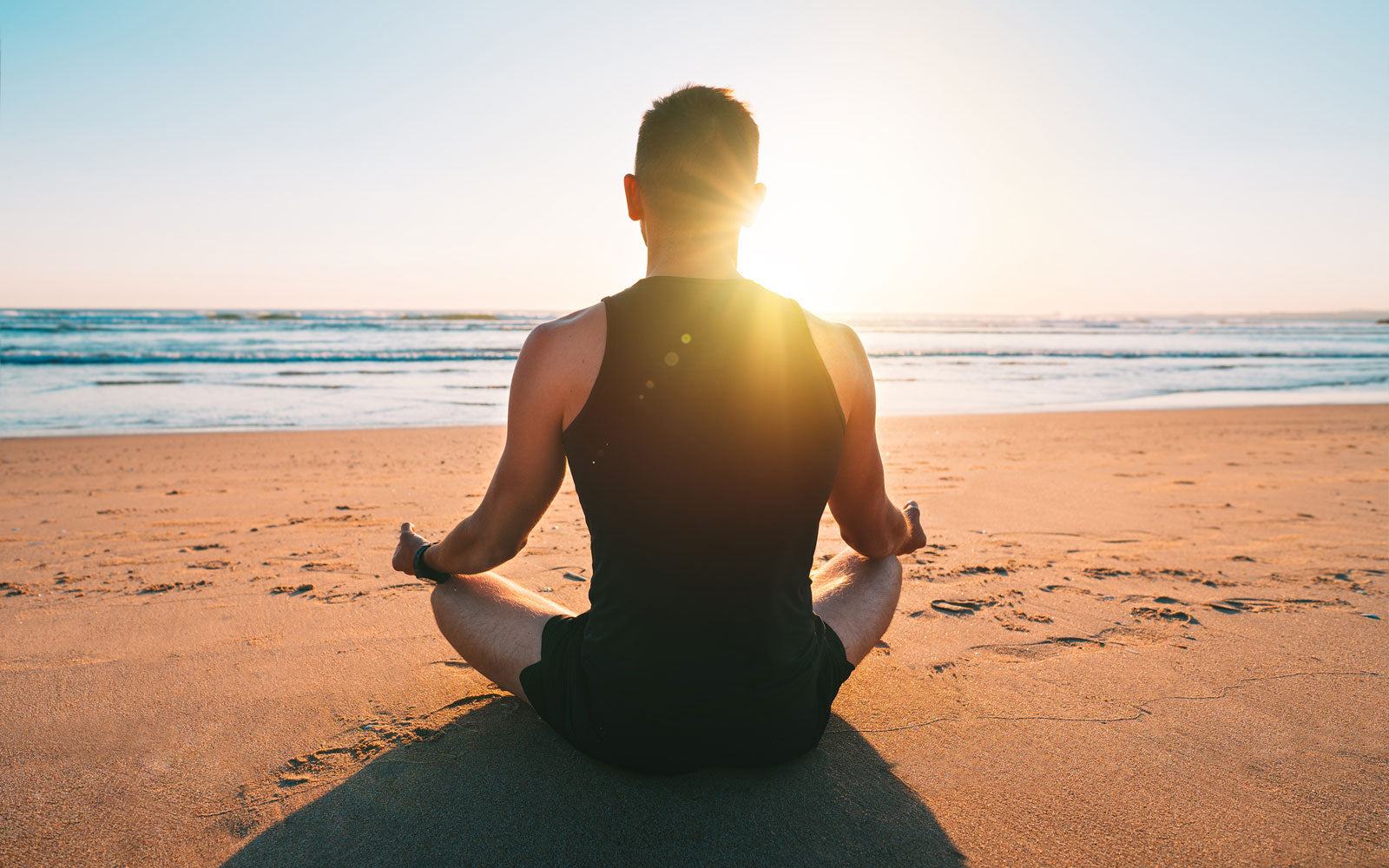 Man meditating on the beach