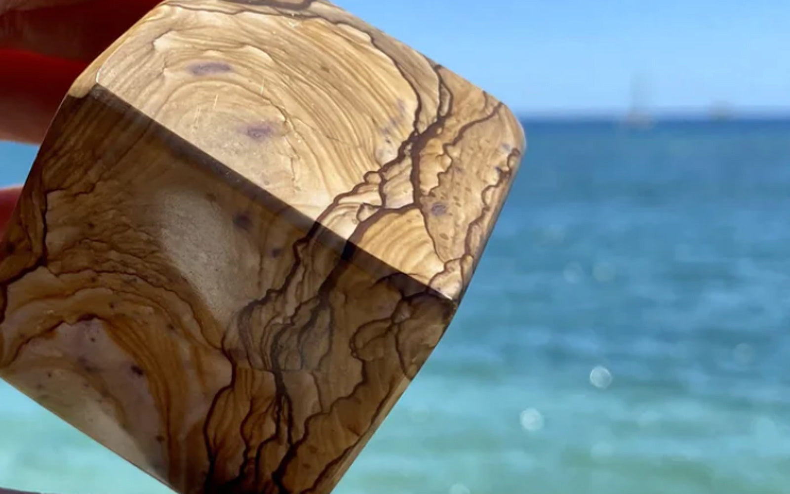 Large picture jasper cube in front of the ocean