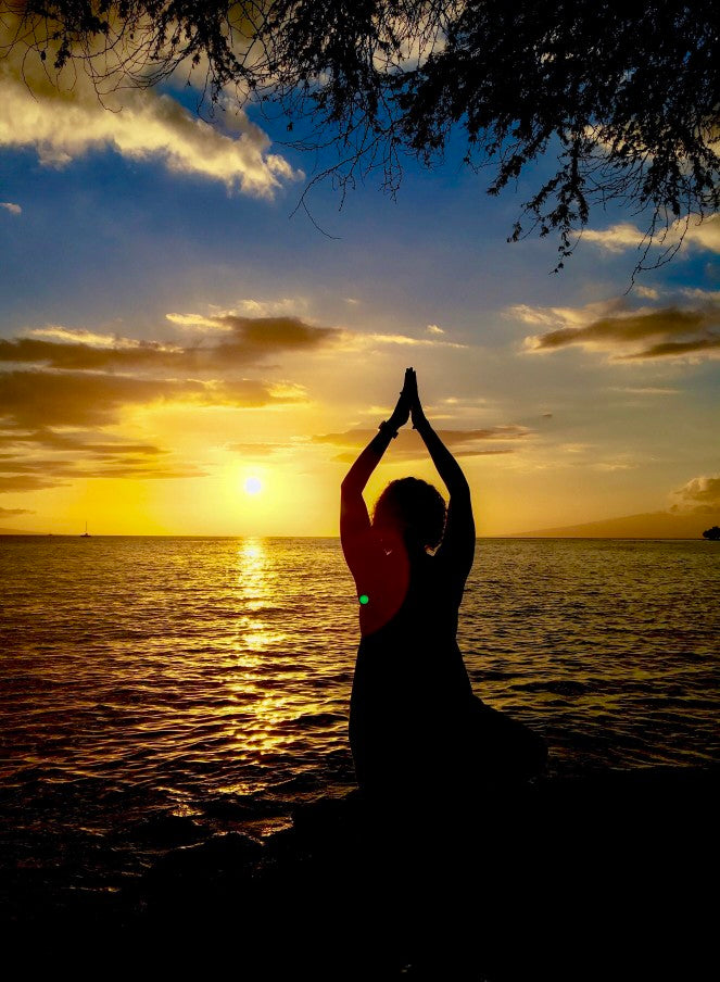 Namaste woman in front of the ocean