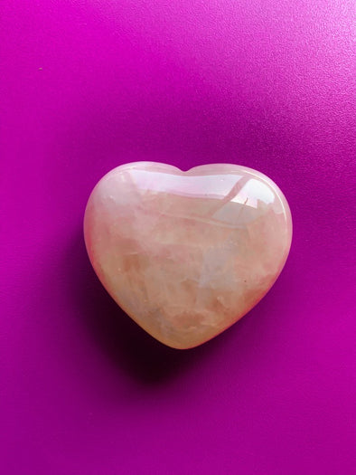rose quartz heart stone on pink background