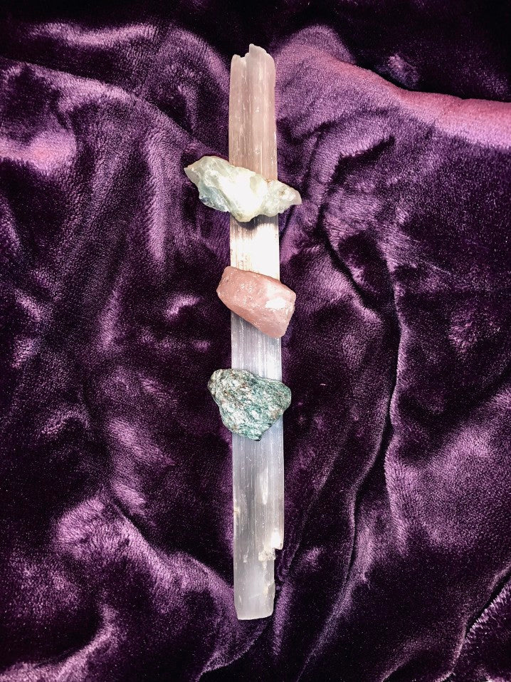 Healing crystals resting on selenite on a purple velvet cloth