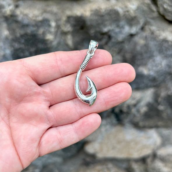 Person Holding Fish Hook Pendant with Swirl Detail