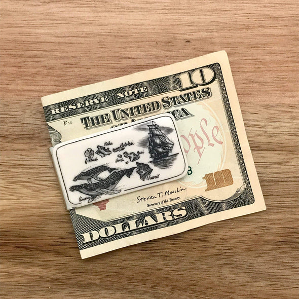 Scrimshaw Style Wide Money Clip featuring humpback whale, Hawaiian islands and ship detail designed by artist Linda Layden with money for size comparison. Money not included with purchase.