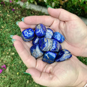 Person holding healing crystal pebbles in Lapis Lazuli