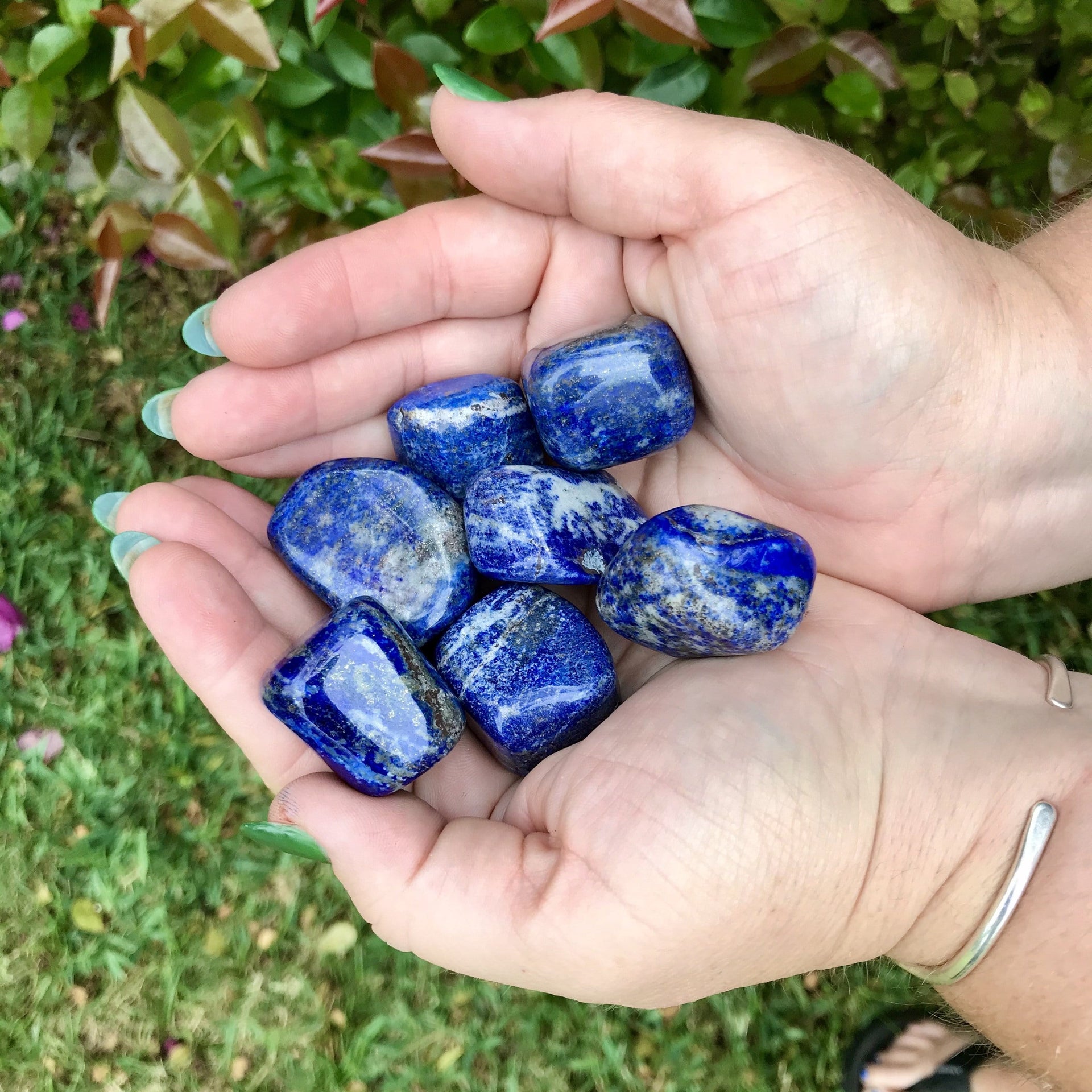 Person holding Lapis Lazuli healing crystal pebbles 